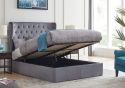 A luxurious grey upholstered ottoman bed frame with a buttoned, wing back headboard.