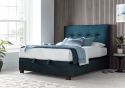 Luxurious deep blue velvet ottoman bed frame with modern dark wooden feet.