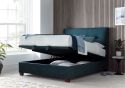 Luxurious deep blue velvet ottoman bed frame with modern dark wooden feet.