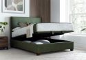 Luxurious moss green velvet ottoman bed frame with modern dark wooden feet.